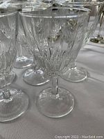 Close-up view of the 14 clear Luminarc Cristal d'Arques crystal wine glasses, showing detailed cut glass patterns.