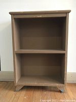 Front view of wood book shelf showing two shelves and chip worn paint
