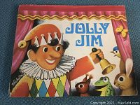 Front cover of the pop-up book 'Jolly Jim' showing the main character dressed as a jester with bell and animals around him.