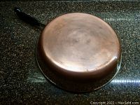 Bottom copper surface of the Revere Ware skillet showing natural patina and wear marks.