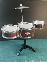 Front view of desktop drum set showing three tom tom drums (two 4.5 inch and one 6 inch) with a cymbal on stand.