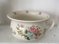 Front view of the chamber pot showing floral decoration and handle