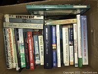 A collection of baseball themed books inside a box including titles such as 'A Game for All Races', 'If at First', and 'The Last Best League'.