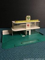 Front view showing two-level structure, BP signage and green base