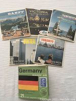 Six View-Master reel packets with original sleeves showing different geographic locations such as Banff, Victoria, Vancouver, Montreal, Toronto and Germany.