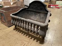 Side angle view of Victorian cast iron fire basket showing overall design and structure.
