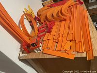 Overall shot of orange straight and curved Hot Wheels track pieces with white and orange support towers.