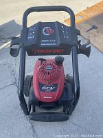 Front angled view of Troy-Bilt pressure washer showing control panel and Honda GCV 190 motor under sunlight outdoors.