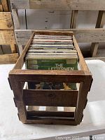 Top view of wooden crate filled with vinyl records standing upright.