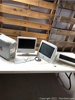 Overview of lot showing Power Mac G4 tower, iMac units, Cinema Display monitor, keyboard and mouse