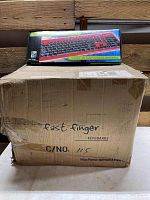 Box containing 20 Fast Finger keyboards with some damage visible on the case.