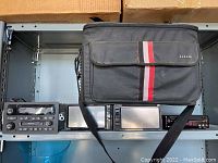 Four car stereos and a Sakar carrying case shown together on a shelf