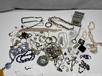 Overview of various estate jewelry items including necklaces, bracelets, rings, and pendants in assorted materials and styles