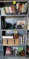 Shelf with various books, binoculars, roller skates, picnic basket, and home decor as described