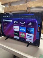 TV powered on showing the Philips Roku interface with various streaming apps visible.
