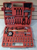 Full view of open orange plastic carrying case with tools fitted in slots