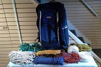 Wide shot of lot showing black duffel bag and all ropes laid out in front on a table.