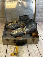 Overall view of the Betty Lytle vintage roller skates with wooden wheels inside their metal case.