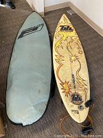 Full view of surfboard and cover on carpeted floor