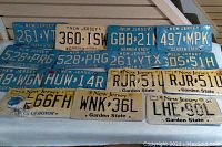 Various New Jersey license plates arranged in two rows, showing front view with visible colors, numbers, and wear.
