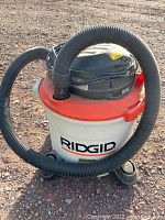 Front view showing RIDGID branding, hose, and wheeled base