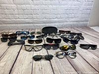 Full view of all sunglasses and eyeglasses laid out showing varying frame shapes and lens colors with protective case in center