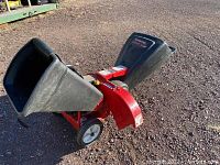 Front side view showing the chutes and wheels on red metal frame.