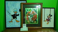 Three framed character pictures of Donald Duck, Bugs Bunny, and Mickey Mouse shown together against a green wall.