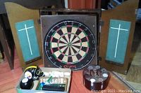 Dartboard cabinet with dartboard inside and some novelty items including Magic 8 ball and Steelers skull in front