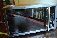 Front view of microwave oven showing the stainless steel door and digital keypad.