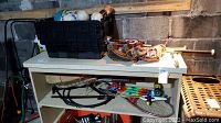 Photo of shelf with baseball bats, tennis racquets, skateboard, and other small sports equipment items stored on it.