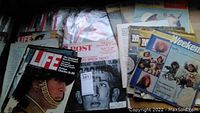 Photo showing assorted Life, Post, Sunday Sun, Weekend magazines stacked with worn covers