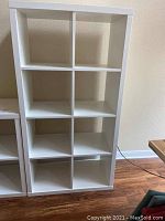 Front view of white laminate cubicle shelf showing six open sections arranged in three rows and two columns.