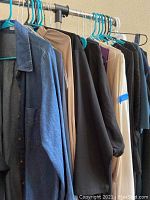 Hanging dresses including denim shirt dress, black and beige dresses