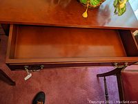 Top view of the wooden console table drawer open showing the interior and brass handle.