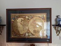 Full view of framed dual-hemisphere world map print under glass