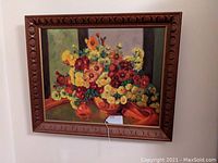 Full view of framed floral still life painting on wall showing colorful flowers and wooden carved frame.