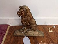 Front and side view of the painted cast iron lion door stop showing the detailed sculpting and base.
