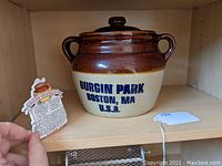 Vintage Durgin Park ceramic beanpot placed on shelf with beige and brown glaze and blue lettering