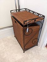 Front and side view of the wicker hamper with black wrought iron frame and hinged wicker lid.