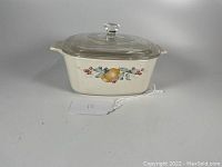 Full front view of Corning Ware Abundance pattern 1.5 liter covered casserole dish with glass lid, showing the detailed fruit and foliage design on a cream background.