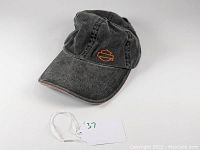 Front view of black denim Harley Davidson baseball cap with orange embroidered logo