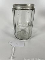 Front view of clear glass coffee canister with octagonal faceted body and embossed 'COFFEE' wording, metal screw-top lid.