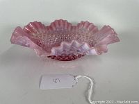 Top and side view of the cranberry colored opalescent glass bowl with ruffled edge and hobnail pattern.