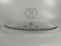 Side view of clear glass serving plate with beaded candlewick edge and heart-shaped beaded handle