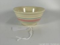 Front view of McCoy Pottery mixing bowl showing pastel pink and blue horizontal bands and cream color.