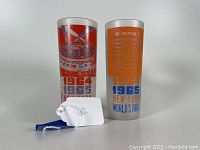 Pair of frosted glass highball tumblers standing side by side, showing front and back designs with colorful graphics and World's Fair dates.