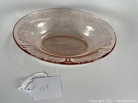 Oval pink Depression glass vegetable bowl showing floral Sharon pattern and central embossed design.