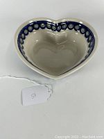 Top view of heart shaped pottery bowl showing intricate blue, white, and red circular ornamental band on interior rim.