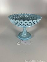 Front view of blue Victorian style fruit compote with reticulated basketweave pattern and textured base.